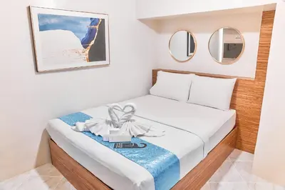 a small bedroom with a bed with a bow at Circuit Hostel in Manila