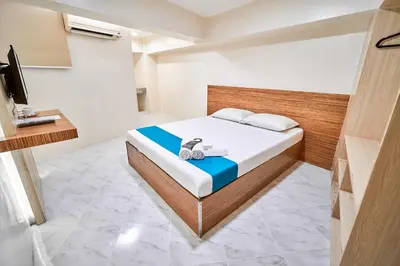 a bedroom with a bed and a television in it at Circuit Hostel in Manila