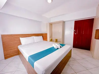 a bedroom with a bed with a red door at Circuit Hostel in Manila