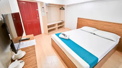 a bedroom with a bed and a red door at Circuit Hostel in Manila
