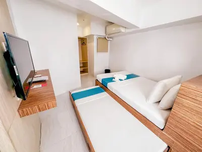 a small room with a bed and a tv at Circuit Hostel in Manila
