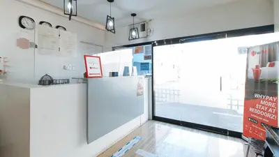 a room with a large window and a refrigerator at RedDoorz near SM Calamba in Laguna