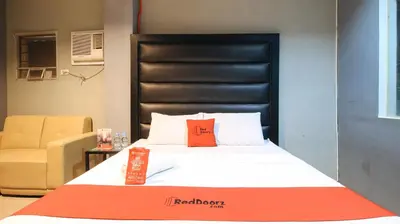 a bed with a red pillow on it in a room at RedDoorz @ P Florentino Street Sampaloc Manila in Manila