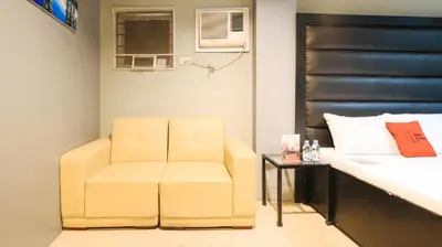 a yellow chair in a room with a bed at RedDoorz @ P Florentino Street Sampaloc Manila in Manila