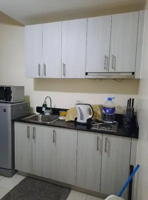 a kitchen with white cabinets and a sink at Green Residence 23rd Floor in Manila