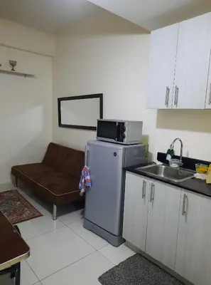 a kitchen with a microwave on top of a refrigerator at Green Residence 23rd Floor in Manila