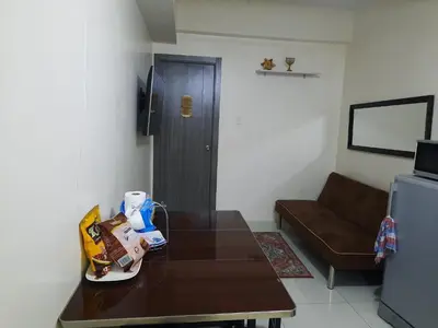 a living room with a table and a couch at Green Residence 23rd Floor in Manila