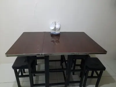 a wooden table with two chairs and a glass at Green Residence 23rd Floor in Manila