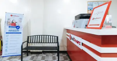 a bench sitting in front of a cash register at RedDoorz Plus near Uptown BGC Mall in Manila