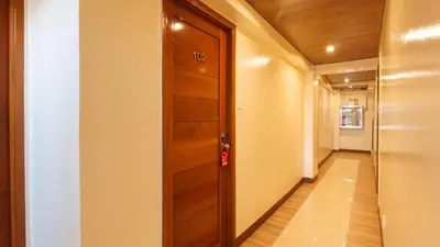 a hallway with a wooden door and a hallway at RedDoorz Plus near Uptown BGC Mall in Manila