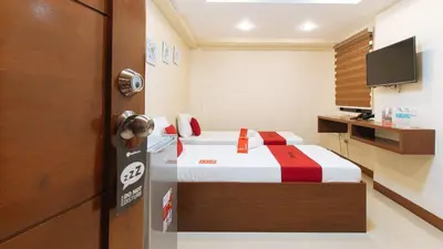a hotel room with a bed and a television at RedDoorz Plus near Uptown BGC Mall in Manila