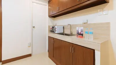 a kitchen with a sink and a microwave at RedDoorz Plus near Uptown BGC Mall in Manila
