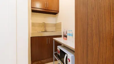 a small kitchen with a sink and a dishwasher at RedDoorz Plus near Uptown BGC Mall in Manila