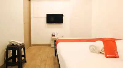 a room with a bed and a tv and a stool at RedDoorz Plus @ San Marcelino Malate in Manila