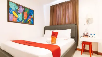 a bedroom with a bed with a painting on the wall at RedDoorz near Mercado del Lago in Manila