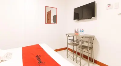 a room with a bed and a tv on the wall at RedDoorz near Mercado del Lago in Manila