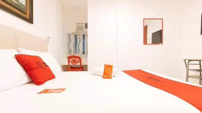 a bedroom with a white bed with red pillows at RedDoorz near Mercado del Lago in Manila
