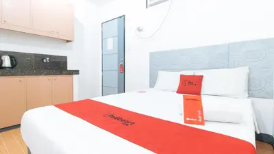 a bedroom with a white bed with a red ribbon on it at RedDoorz at CAA Road Las Pinas in Manila