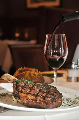 a plate of food with a steak and a glass of wine at City View at MAKATI Prime Luxury in Manila