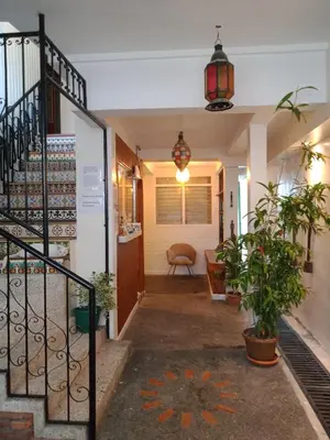a hallway of a house with a staircase and plants at Airport Hostel Manila in Manila
