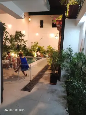 a woman sitting in a chair next to a pool at Airport Hostel Manila in Manila