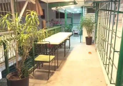 a restaurant with tables and plants in a room at Airport Hostel Manila in Manila