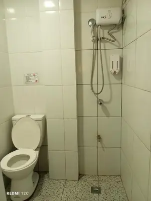 a bathroom with a toilet and a shower at Airport Hostel Manila in Manila