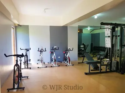 a gym with bikes and exercise equipment in a room at Centropolis King Bed Deluxe in Manila