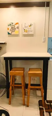 a table with two wooden stools in a room at Centropolis King Bed Deluxe in Manila