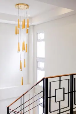 a staircase with two chandeliers in a house at Airo Hotel Manila in Manila