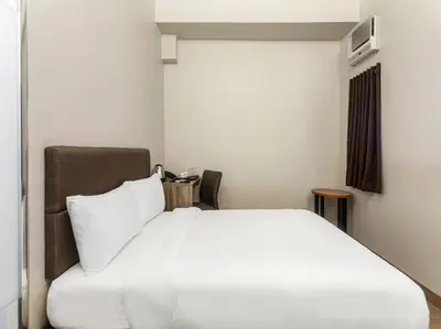 a bedroom with a white bed and a window at Airo Hotel Manila in Manila