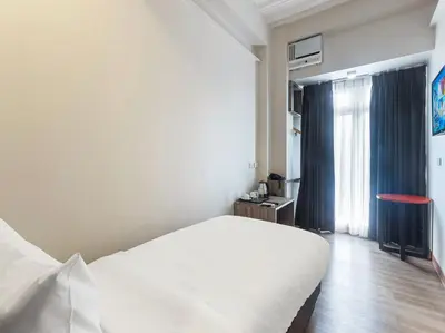 a bedroom with a white bed and a window at Airo Hotel Manila in Manila