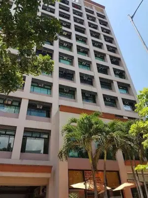 a tall building with palm trees in front of it at Alabang Condotel in Studio One Condominium in Manila