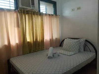 a bedroom with a bed and a window with curtains at Alabang Condotel in Studio One Condominium in Manila