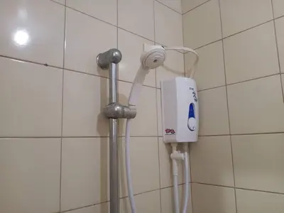 a white hair dryer is attached to a wall at Alabang Condotel in Studio One Condominium in Manila
