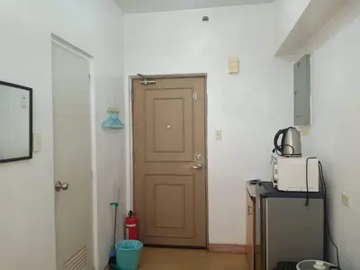 a door in a room with a microwave and a refrigerator at Alabang Condotel in Studio One Condominium in Manila