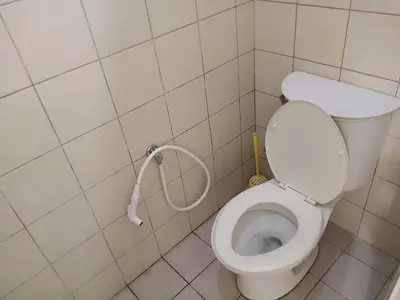 a small bathroom with a toilet with a hose at Alabang Condotel in Studio One Condominium in Manila