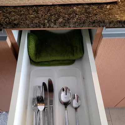 a drawer with silver utensils in a counter at Andy's Place One Eastwood Tower 1 in Manila