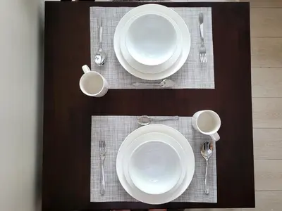 a table with white plates and silverware on it at Andy's Place One Eastwood Tower 1 in Manila
