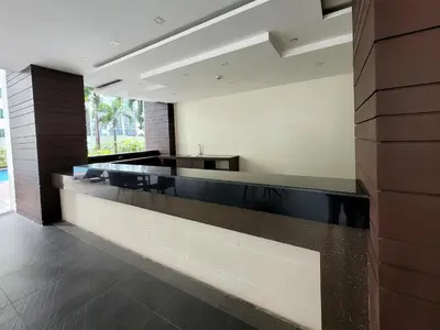 a lobby with a long counter in a building at Andy's Place One Eastwood Tower 1 in Manila