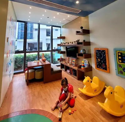 a child sitting on the floor in a room with toy cars at Andy's Place One Eastwood Tower 1 in Manila
