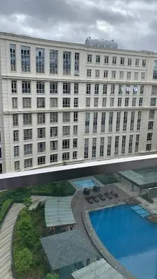 a large building with a swimming pool in front of it at 81 Newport Boulevard Cluster 4 - 8F across NAIA Airport, Terminal 3 in Manila