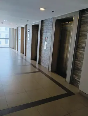 a hallway of a building with doors and a tile floor at 81 Newport Boulevard Cluster 4 - 8F across NAIA Airport, Terminal 3 in Manila