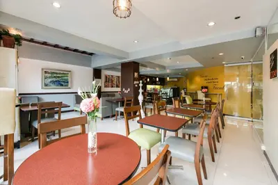 a restaurant with tables and chairs with flowers on them at Festive Hotel Makati in Manila