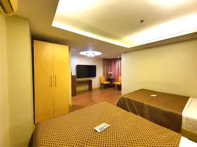 a hotel room with a bed and a television at Festive Hotel Makati in Manila