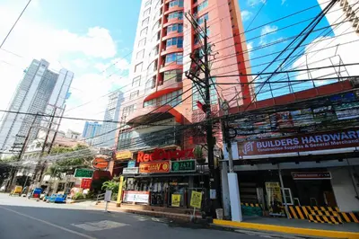 a city street with a tall red building at RedDoorz at The Providence Tower in Manila