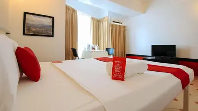 a hotel room with two beds and a television at RedDoorz at The Providence Tower in Manila
