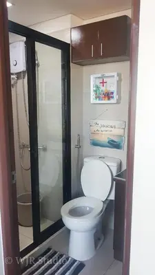 a bathroom with a white toilet and a shower at Choco Condotel- Anuva Prime 1 Couple Suite Lakeview in Manila