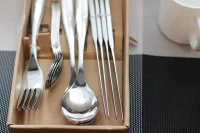 a wooden tray withsilver forks and spoons and forks at A2J Luxury BGC Balcony Suite Near SM AURA Taguig in Manila