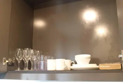 a shelf with cups and glasses on a wall at A2J Luxury BGC Balcony Suite Near SM AURA Taguig in Manila